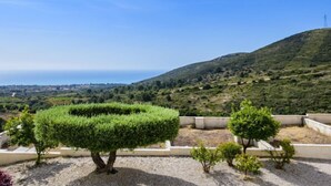Un giardino curato con siepi ben potate e vista su un paesaggio collinare.