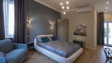 A modern bedroom with a bed, a sofa, a painting, and a ceiling light fixture.
