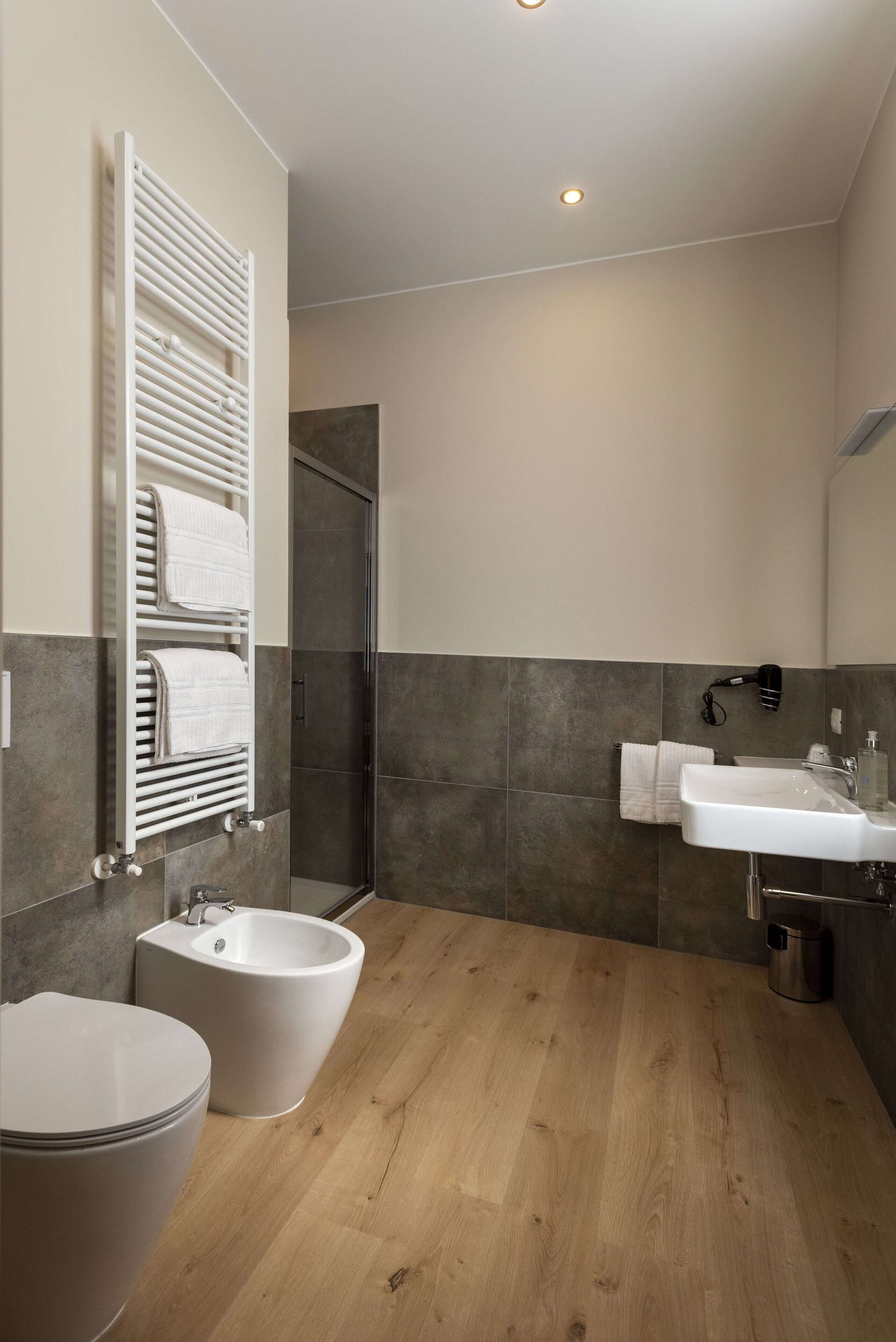 A modern bathroom with a toilet, bidet, and sink.