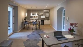 Une cuisine moderne avec un coin bar, une table à manger avec des chaises et un ordinateur portable posé sur une table.