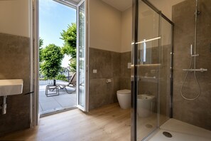 Habitación de lujo | Baño | Regadera, regadera tipo lluvia, secadora de cabello, pantuflas 