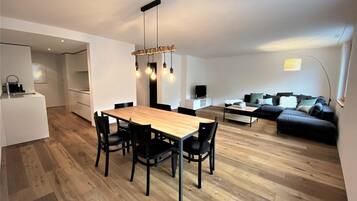 Un appartement moderne comprenant un coin repas, un salon et une cuisine.
