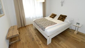 Ein Schlafzimmer mit Bett, Nachttisch, Lampe und Wanddeko.