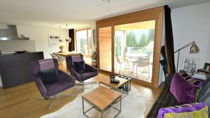 A modern living room with a sofa, two armchairs, a coffee table, and a dining area with a table and chairs. - Uehlinger Züger by Interhome (Valbella)