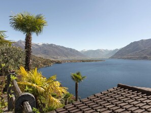 Une terrasse avec vue sur un lac et des montagnes.