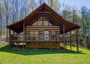 A wooden cabin with a balcony, surrounded by trees. - Convenient Pigeon Forge Cabin-Two Bedroom Pool Table Internet- (Pigeon Forge)