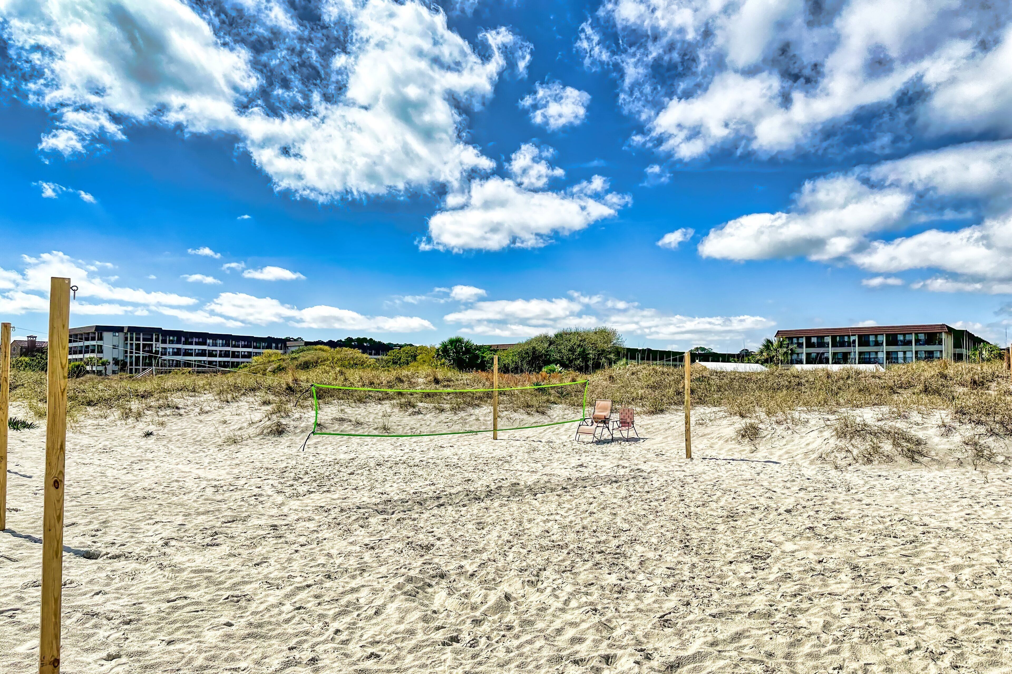 Ein Beachvolleyballfeld mit Netz, umgeben von Sand und Holzpfosten.
