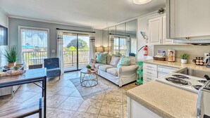 A modern kitchen with a dining area, large windows, and a view of the outdoors. - Ocean Front Condo with Resort Amenities, Short Walk to Beach (Hilton Head Island)