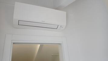 Un condizionatore d'aria bianco montato sopra una porta bianca.