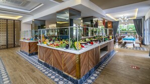 Un espace buffet doté d’un îlot central, de rampes en verre et d’un coin repas avec une table et des chaises.