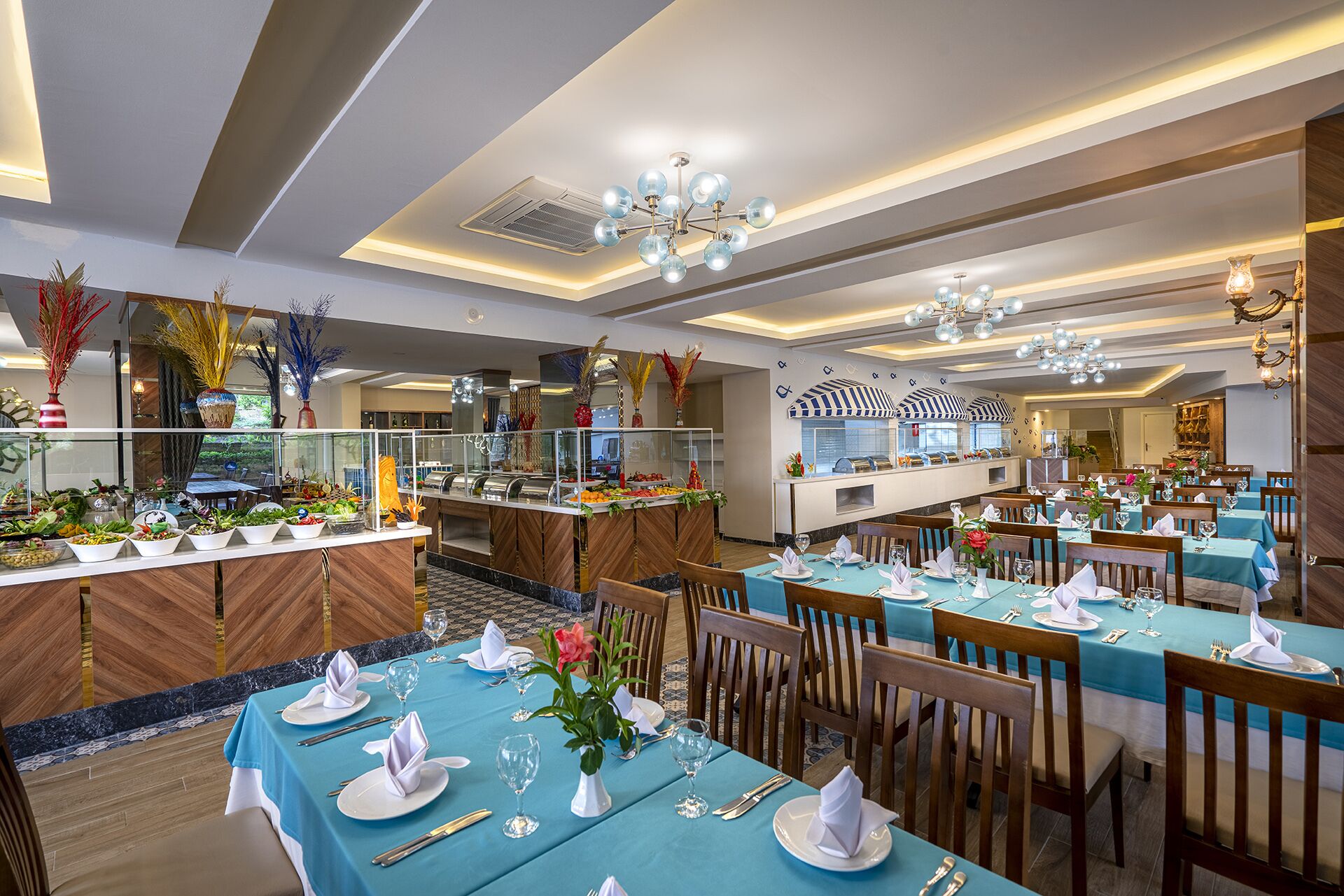A restaurant with multiple dining tables set with blue tablecloths, white napkins, and glassware.