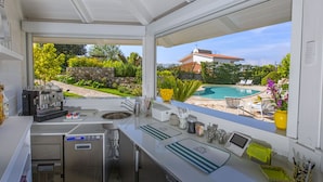 Cocina moderna con vistas a una piscina y jardín.