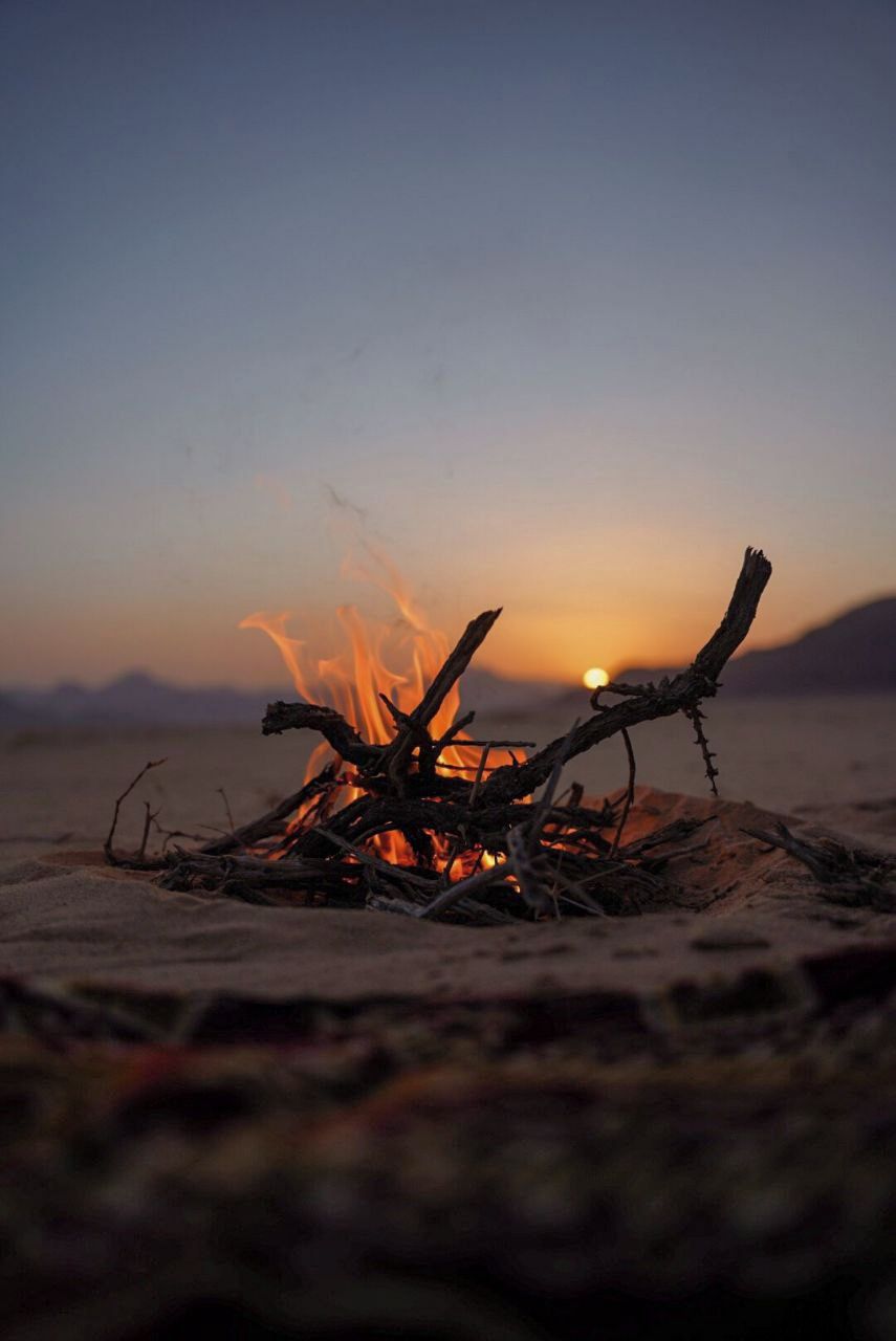 A campfire with a sunset in the background.