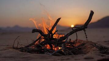 A campfire with a sunset in the background.