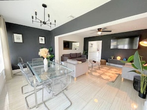Enjoy meals at the glass dining table surrounded by comfortable chairs in this spacious living area.