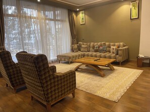 Luxury-Apartment, Stadtblick | Wohnbereich | 55-Zoll-LED-Fernseher mit Kabelempfang