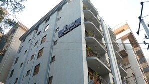 Un edificio de varios pisos con balcones, un letrero que indica que es un apartamento de huéspedes y ventanas visibles.