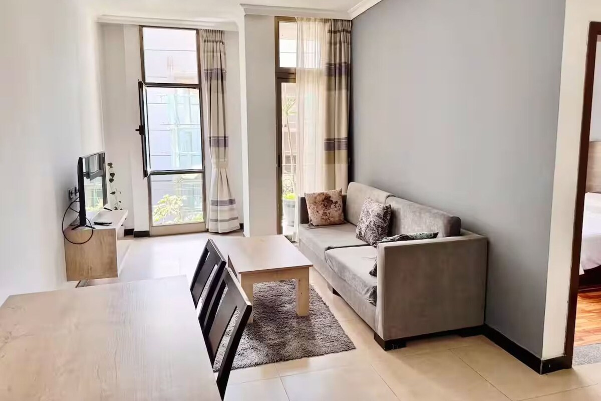 Un salon moderne avec un canapé, une table à manger et un téléviseur.