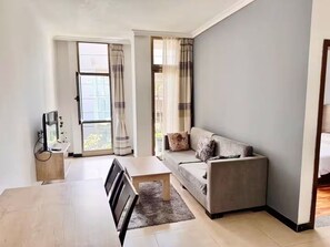 Un salon moderne avec un canapé, une table à manger et un téléviseur.