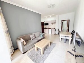 En moderne stue med sofa, sofabord og spiseområde.