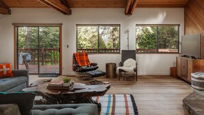 A spacious living room with a large window, a fireplace, and a cozy seating area. - Lay-Z-Bones ~ AC & Pool Access! (Dorrington)