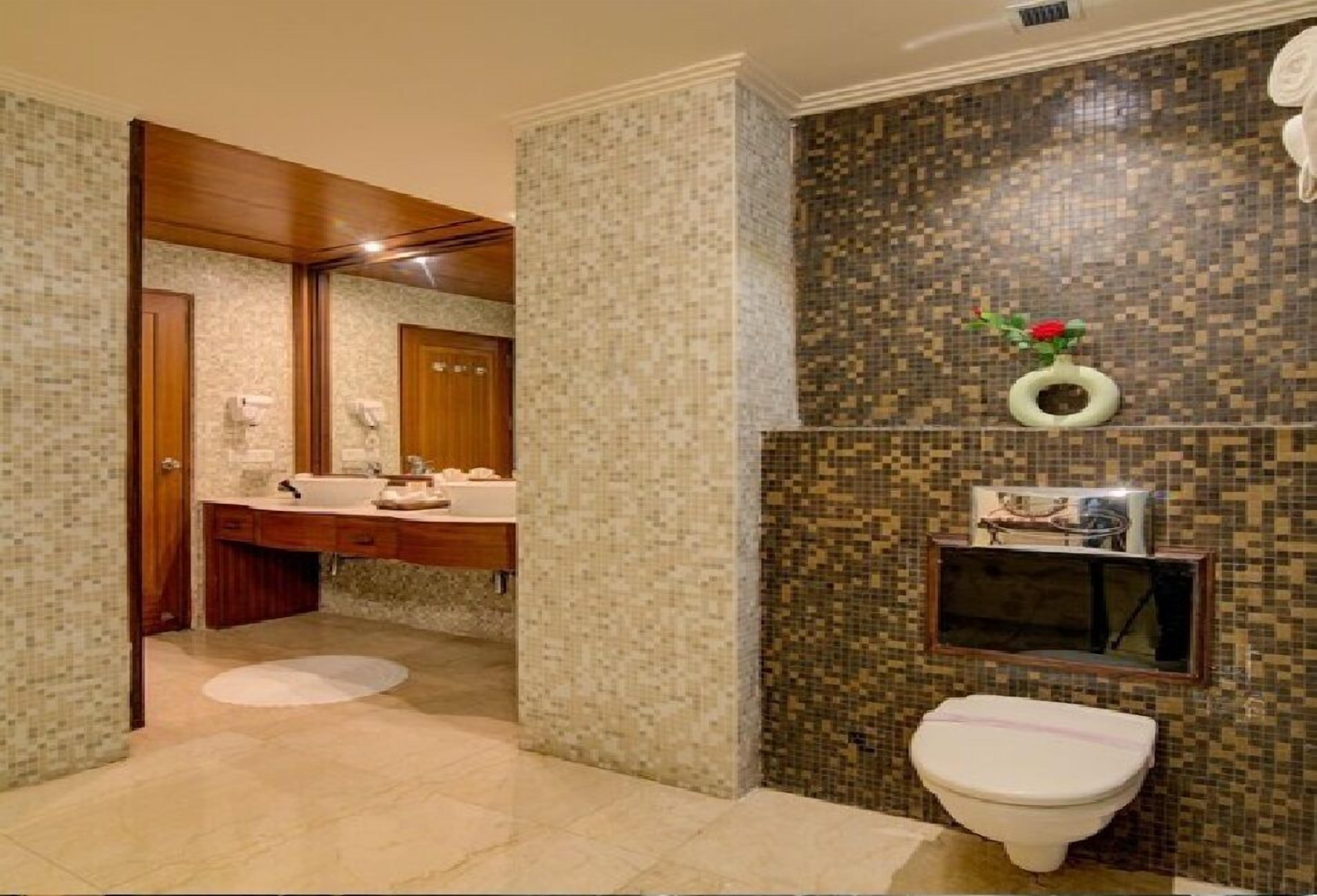 Un baño con tocador, lavamanos e inodoro.