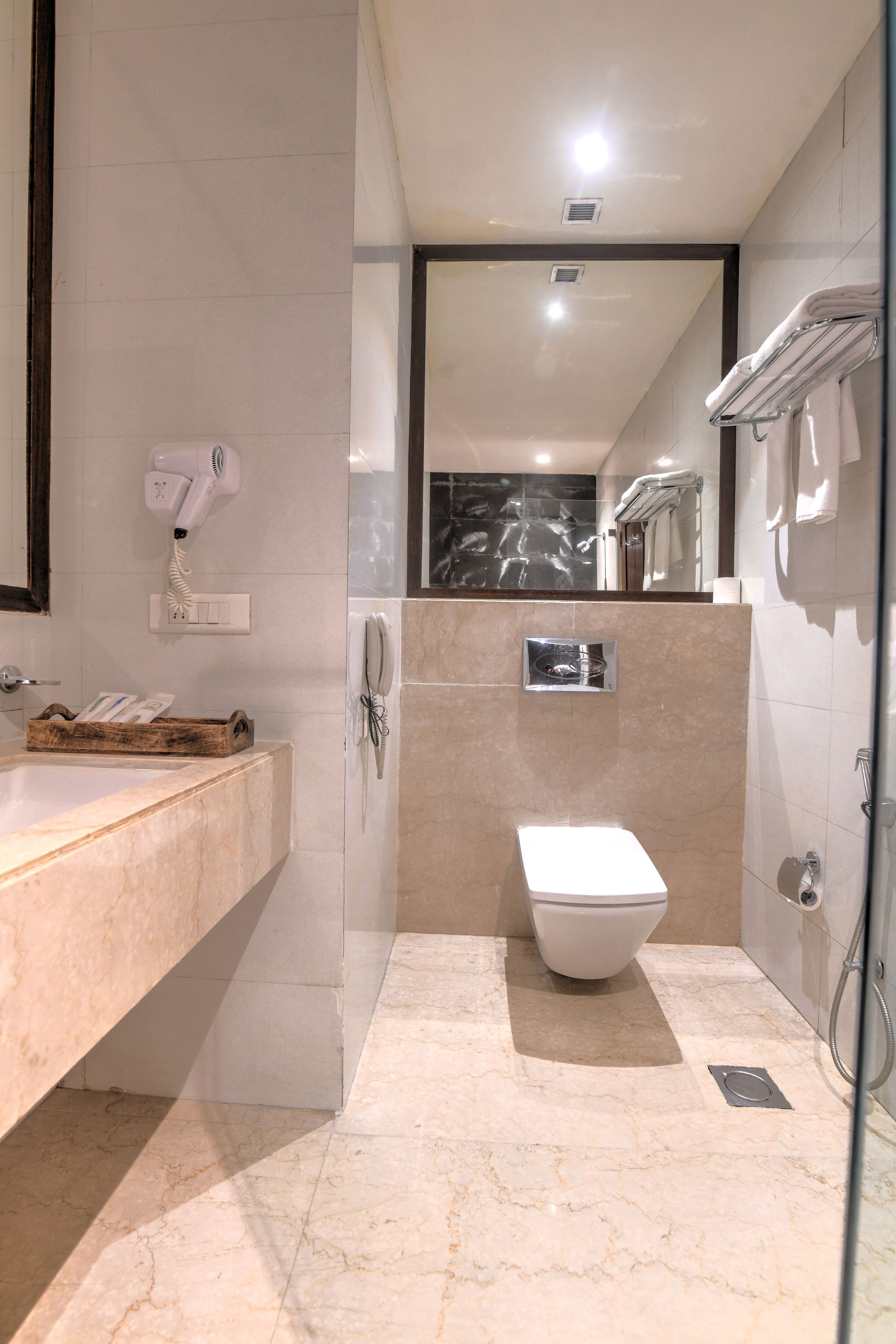 A modern bathroom with a marble sink, a toilet, and a shower area.
