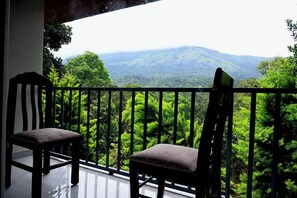 A balcony with two chairs and a view of a mountainous landscape. - Spring Muunnar (Devikolam)