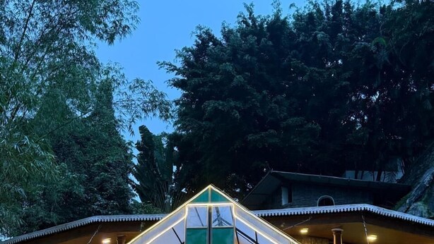 A hotel named 'Spring' with a stone facade, a covered entrance, and potted plants around.