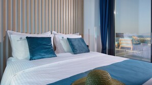 Ett hotellrum med en säng, kuddar, en hatt och utsikt över omgivningarna.