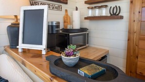 Una cocina con microondas, cafetera y un letrero que dice 'Welcome Y'all'.