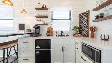 Fridge, microwave, coffee/tea maker, cookware/dishes/utensils