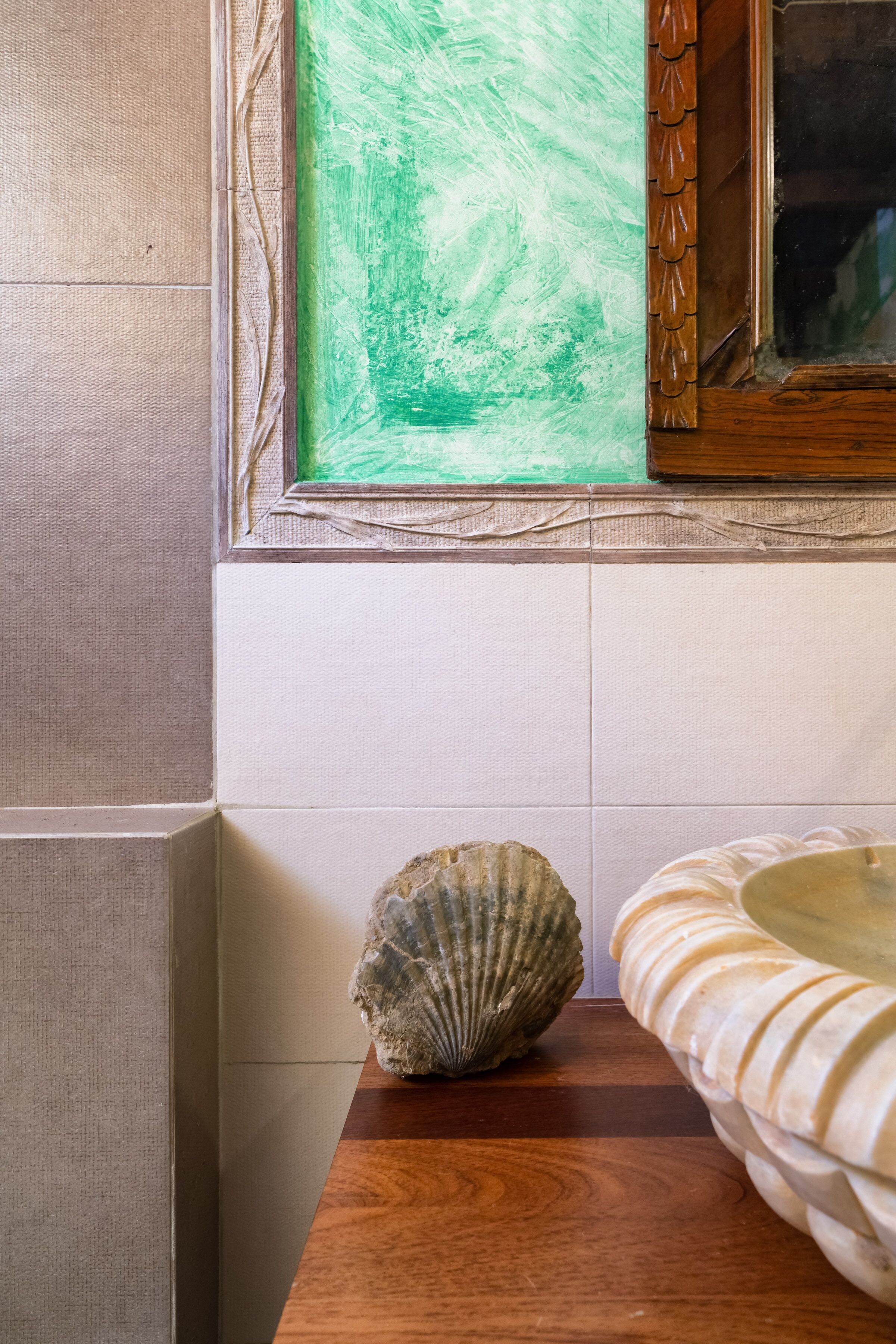 A bathroom with a wooden vanity, a white sink, and a framed mirror above the mirror.