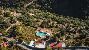 An aerial view of a property with a swimming pool, terraced gardens, and a road. - Nassibe (Mylopotamos)