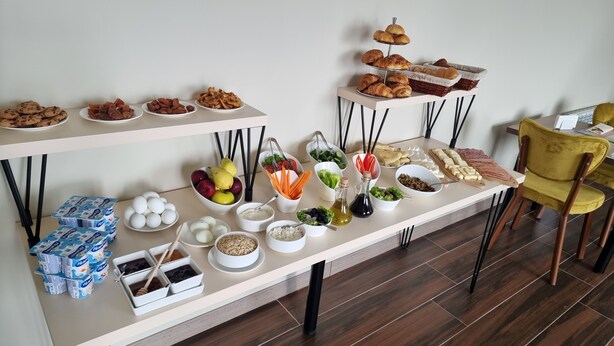 Una mesa de buffet con diversos alimentos y salsas.