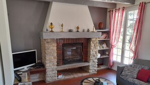 A living room with a stone fireplace, a television, a sofa, and a coffee table. - Beautiful Quercy house near the Chemin de St Jacques (LUNAN)