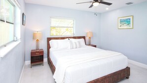 A bedroom with a bed, nightstands, a ceiling fan, a window, and a picture on the wall. - Paradise Vacation Home for entire family (Boynton Beach)