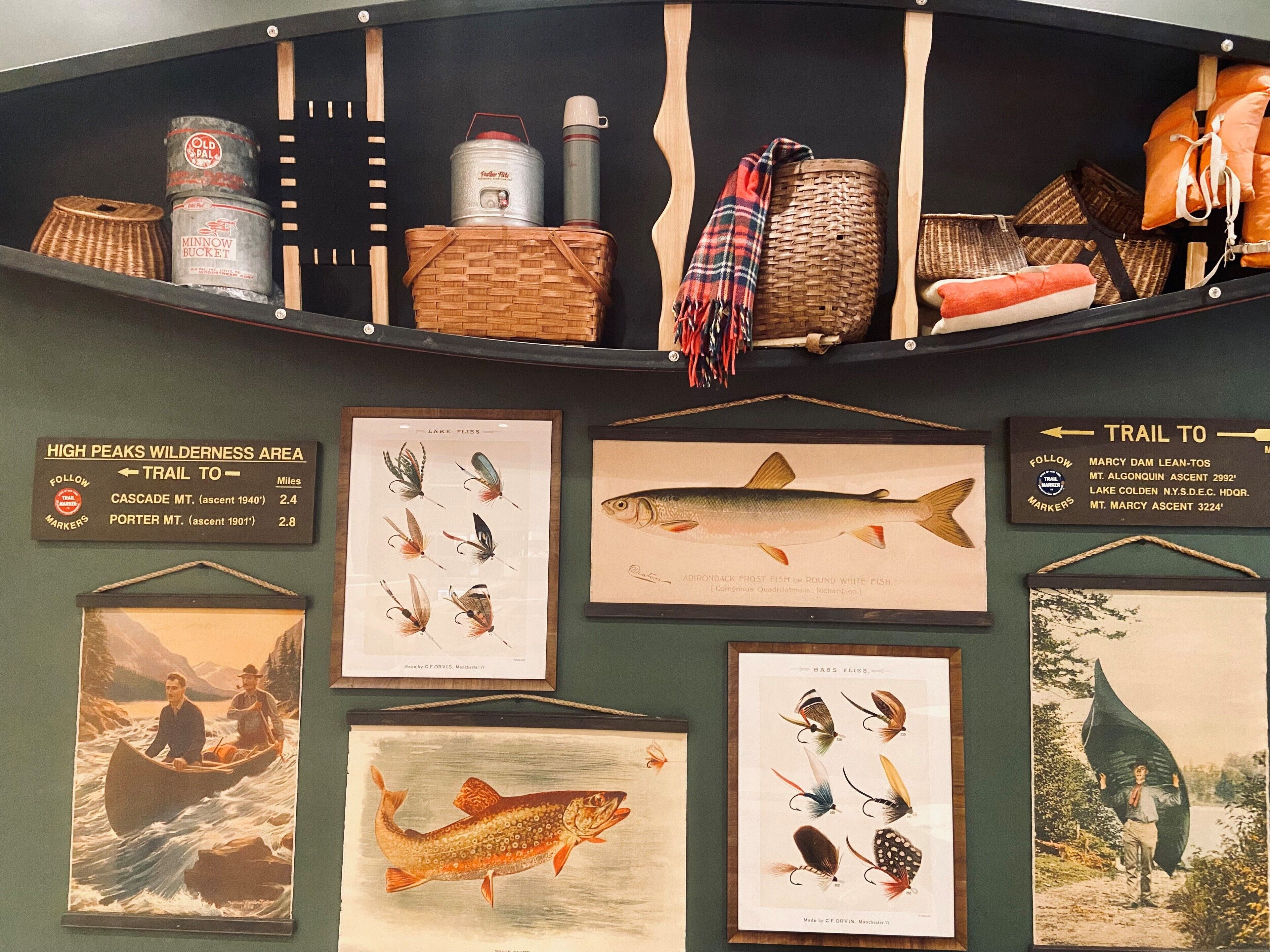 A display of fishing lures, a canister, a thermos, and a map indicating trails to Cascade and Porter Mountains.