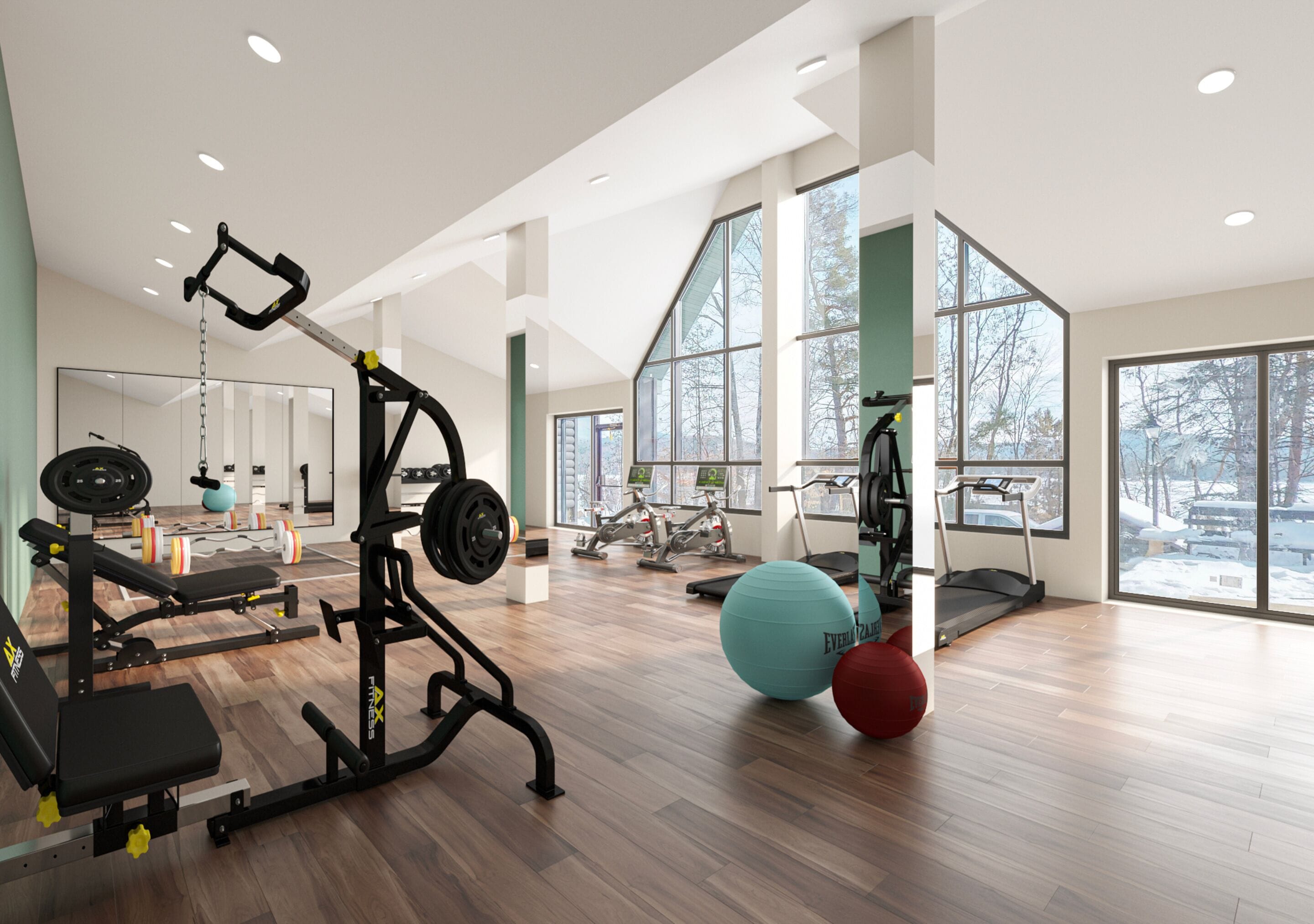 A spacious gym with various exercise equipment, large windows, and a wooden floor.