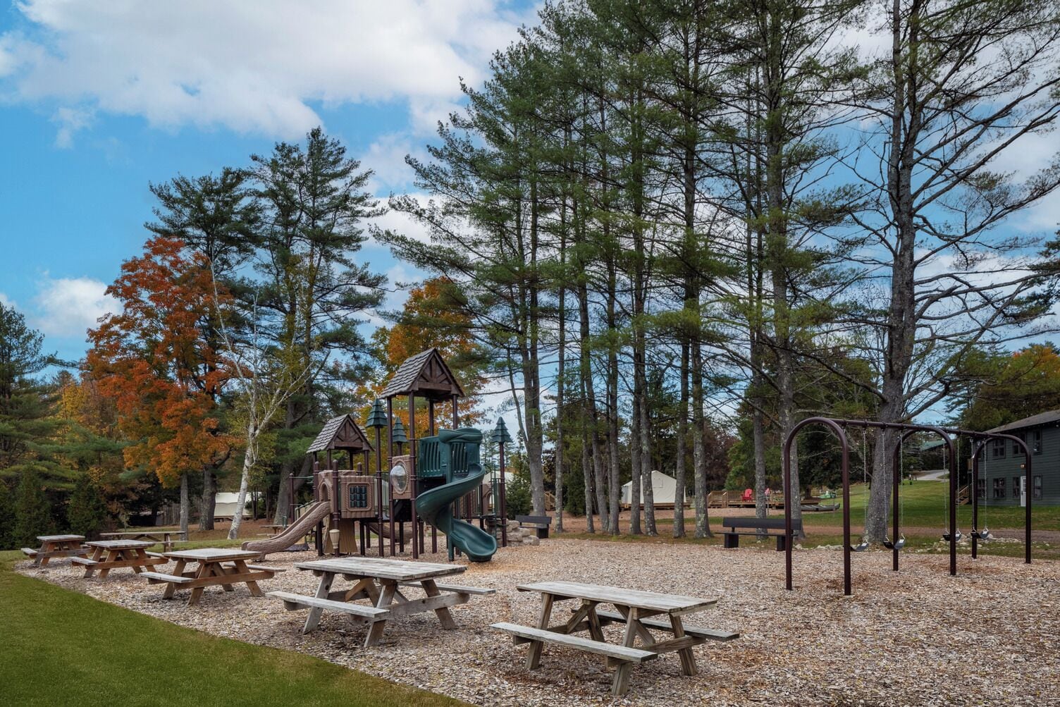 Ein Spielplatz mit Picknicktischen und einer Spielgerüst.