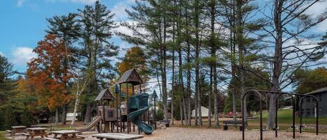 Un parque infantil con mesas de picnic y juegos.