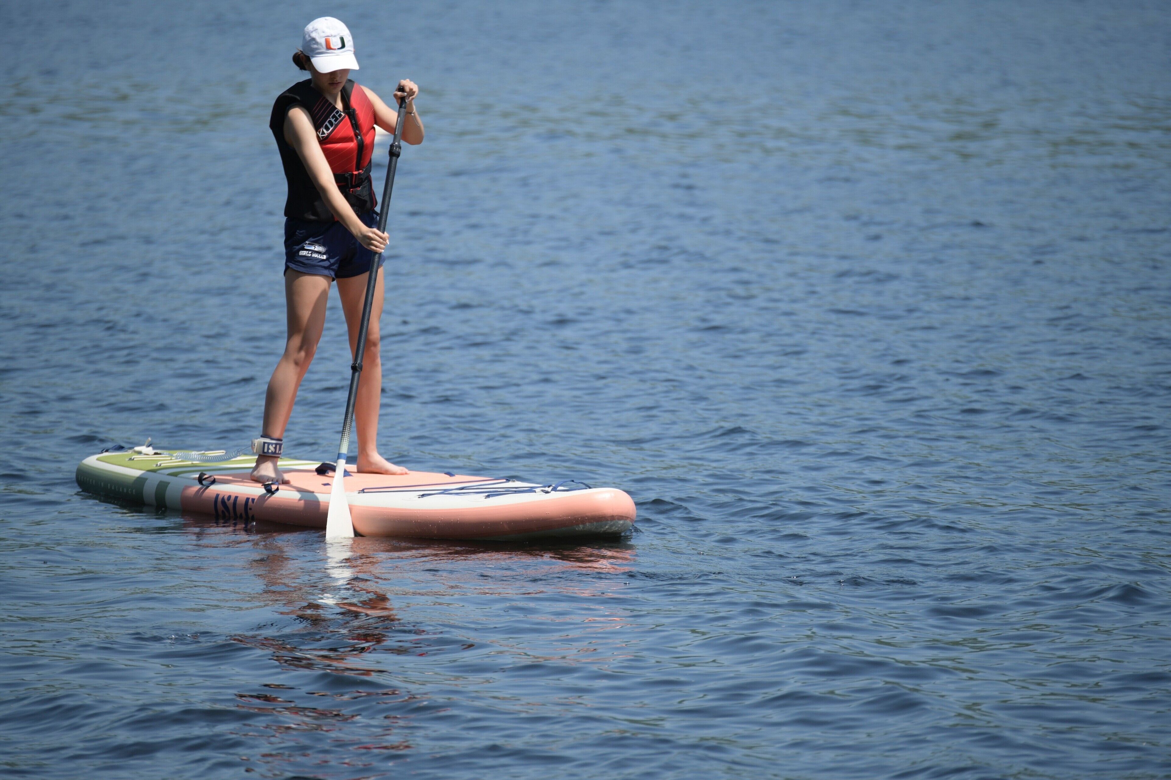 A person paddleboarding on a calm body of water.