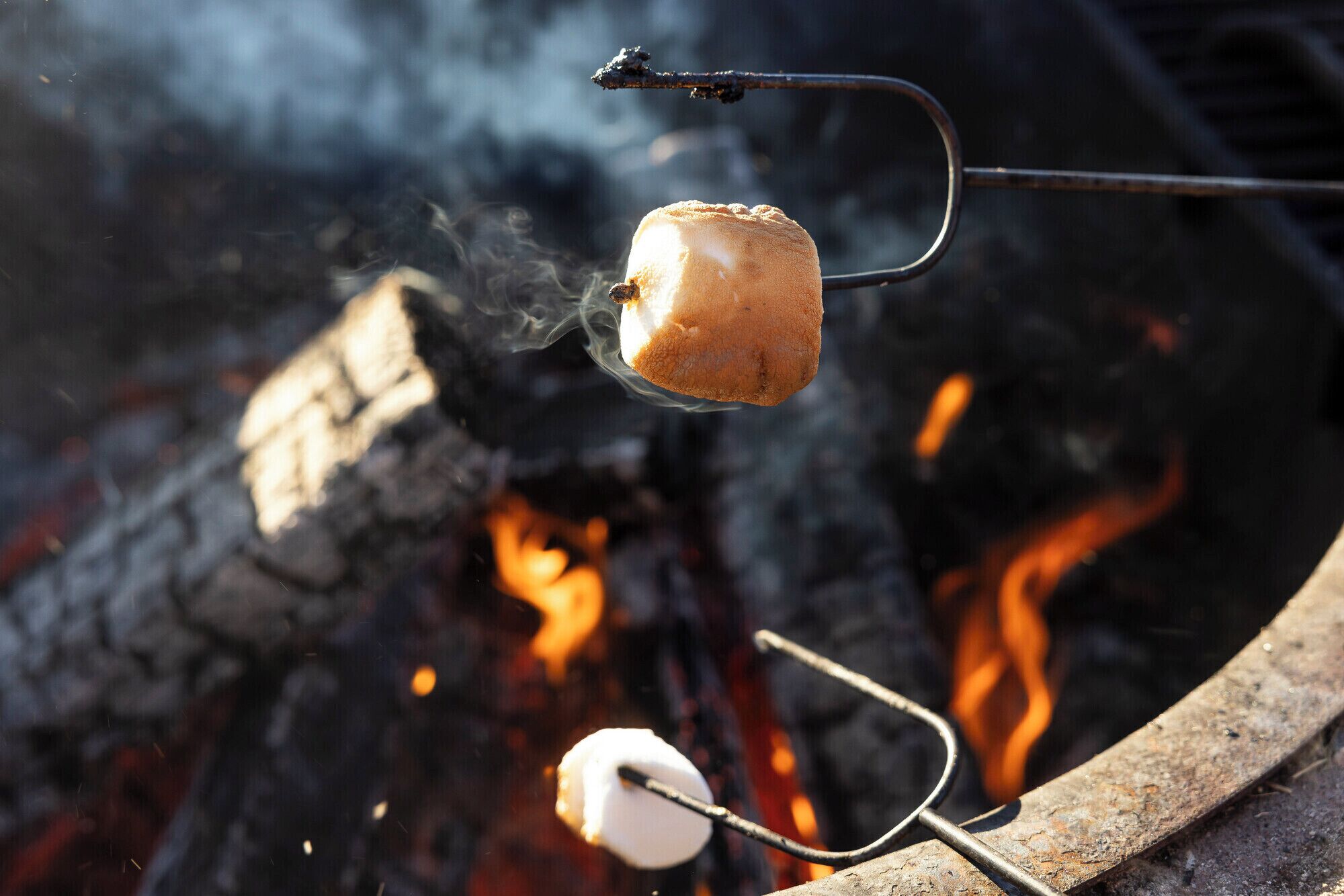 Two marshmallows being roasted over an open flame.