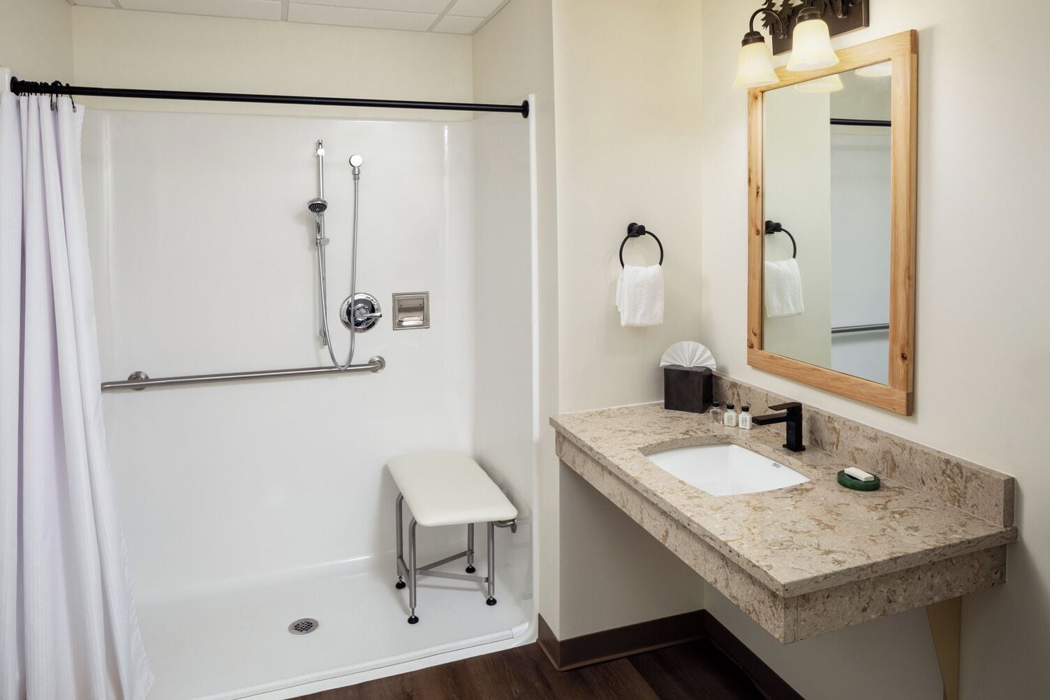 A modern bathroom with a walk-in shower, a vanity with a sink, and a mirror.