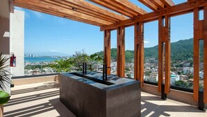 Un balcon offrant une vue sur la ville et les montagnes.