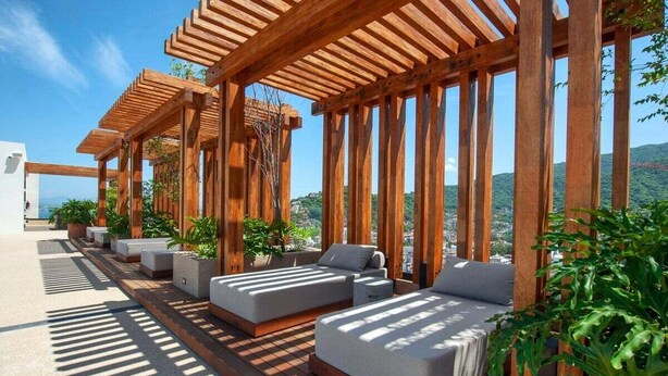 Une terrasse sur le toit agrémentée de pergolas en bois, d’espaces de détente en plein air et de plantes en pot.