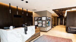 A reception area with a marble counter, framed pictures on the wall, and a wooden reception desk. - Mountain Modern 3 Bedroom Deluxe Condo, Sleeps 10 by RedAwning (Park City)