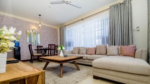 A living room with a sofa, coffee table, and dining area.