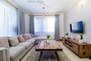 Executive appartement | Woonruimte | Een 32-inch smart-tv met kabelzenders en een televisie