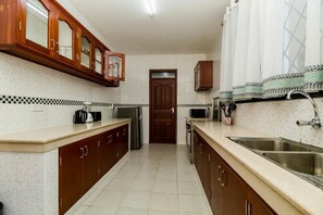 Appartement exécutif | Cuisine privée | Réfrigérateur, four à micro-ondes, surface de cuisson